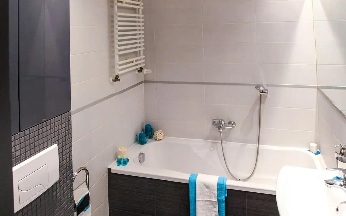Small tidy bathroom with a scrubbed tub and one towel on the rail