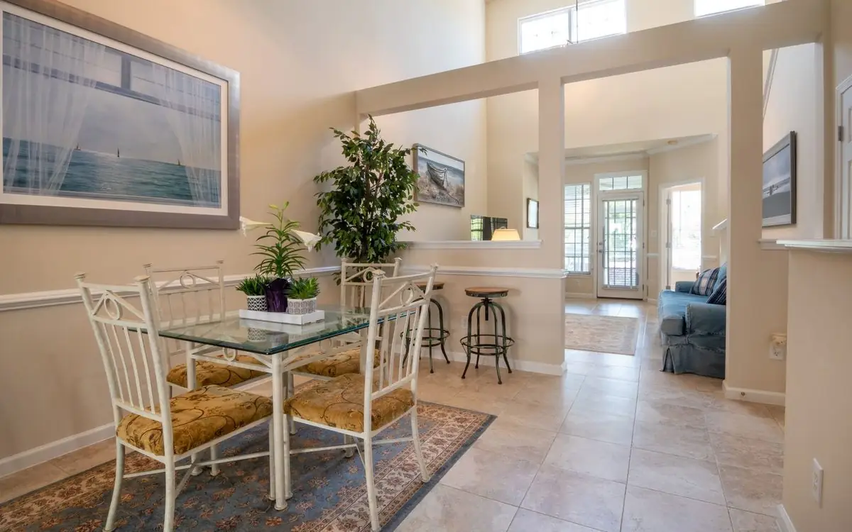 Dining room with a clear glass table, chairs pushed in, and one large piece of art