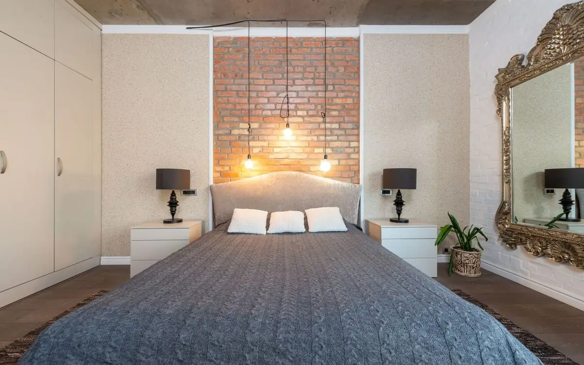 Primary bedroom with a made bed, layered white pillows, and matching lamps on both nightstands